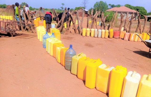 The daily struggle for basic dignity. Families queue for hours under intense conditions just to fill basic water containers.